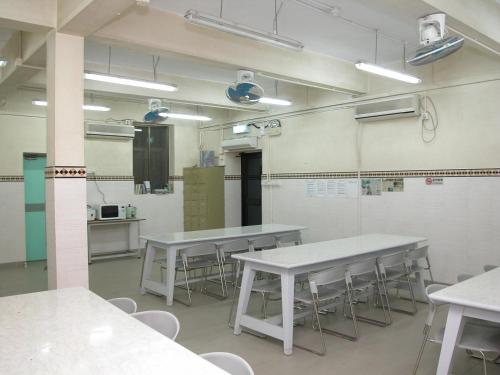 a classroom with tables and chairs in a room at YHA Ngong Ping SG Davis Youth Hostel in Hong Kong