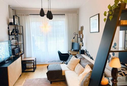 a living room with a couch and a tv at Cozy Peetri apartment with terrace in Petrikyula