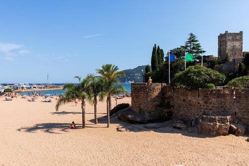 einen Strand mit Palmen und Menschen am Strand in der Unterkunft Villa Marina Cottage in Mandelieu-la-Napoule