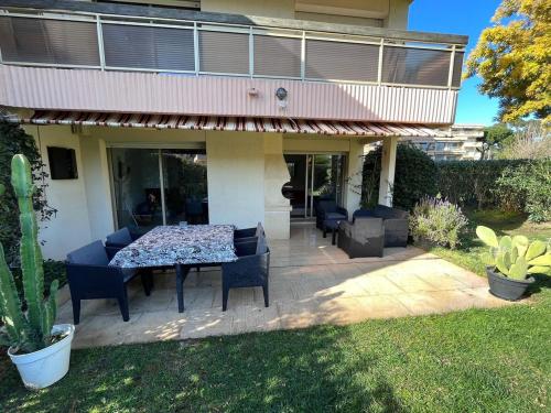 eine Terrasse mit Tisch und Stühlen vor einem Haus in der Unterkunft Villa Marina Cottage in Mandelieu-la-Napoule