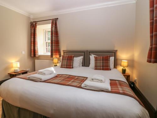 Un dormitorio con una cama grande con toallas. en The Old Laundry Cottage, en Perth