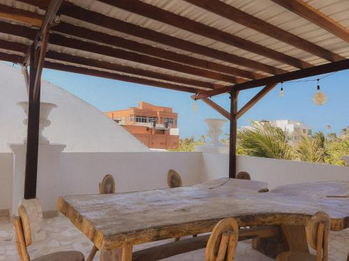a wooden table on a balcony with a view at Surfer Grill, alojamiento en puerto Colombia, pradormar, Habitación Suite in Pradomar