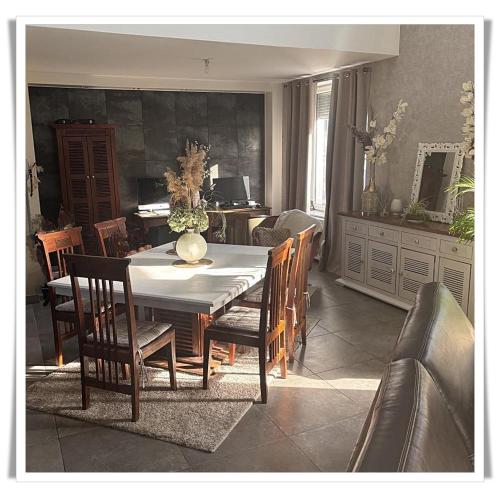 une salle à manger avec une table et des chaises dans l'établissement Superbe appartement au coeur du Jura, à Champagnole