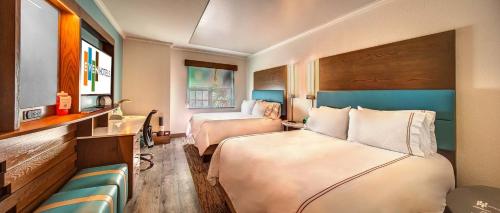 a hotel room with two beds and a couch at EVEN Hotels Sarasota-Lakewood Ranch by IHG in Sarasota