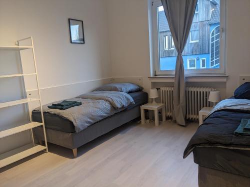 a bedroom with two beds and a window at Monteurwohnung Ferienwohnung Business Appartement Mettmann 1 OG in Mettmann