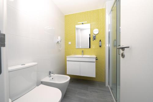 a bathroom with a toilet and a sink and a shower at Casa Limão - Senhora da Rocha, Algarve in Porches