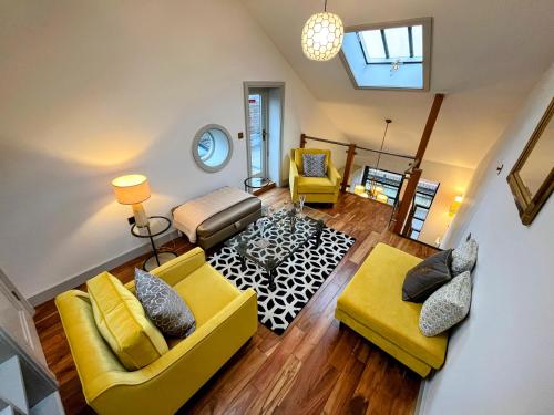a living room with two yellow couches and a table at New Forest Fordingbridge - Art Deco Unique Apartment in Fordingbridge