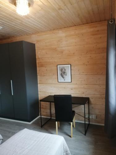 a room with a table and a chair and a wall at Villa Saimaan Valo in Imatra