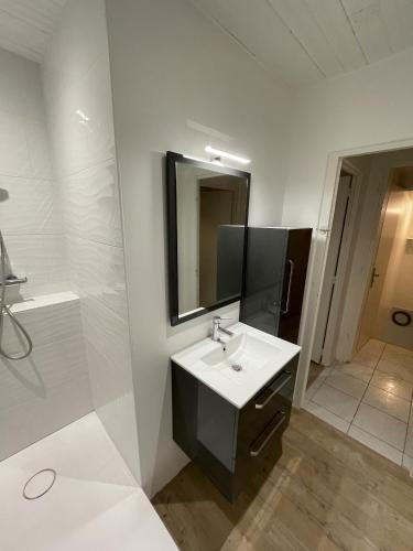 une salle de bain avec un lavabo, un miroir et une douche dans l'établissement Appartement à 300m de la Plage de Ste Marie S/Mer, à Pornic