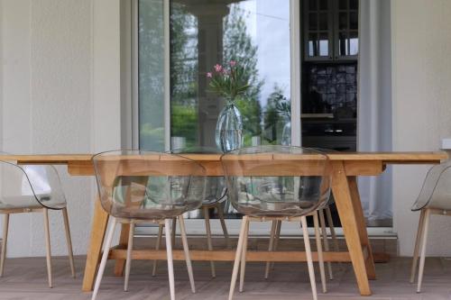 a wooden table with two clear chairs and a vase on it at Nice villa with a view in Saint-André-de-Cubzac