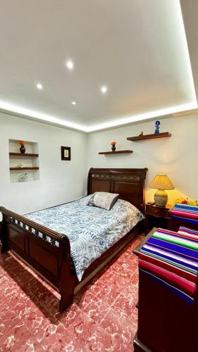 a bedroom with a bed and a lamp on a red carpet at Alojamiento en el Centro Histórico in Oaxaca City