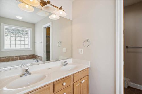 a bathroom with two sinks and a large mirror at Dream Catcher in Nags Head
