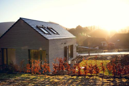 a small house with the sun setting behind it at Exklusive Cabins am Rursee inmitten der Natur – mlab relax Eifel in Simmerath
