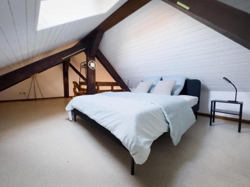 une chambre avec un grand lit dans un grenier dans l'établissement Duplex centre ville, à Soultz-Haut-Rhin