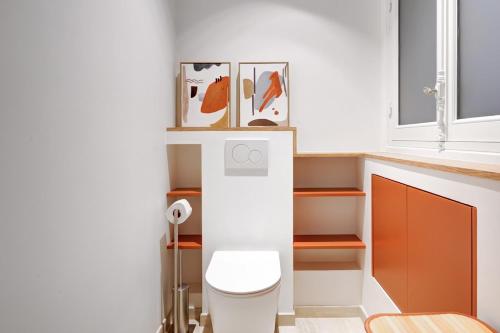 La salle de bains est pourvue de toilettes et de peintures murales. dans l'établissement Prestige Marais XL, à Paris