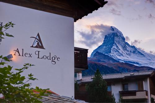 a sign for alex lodge with a mountain at Alex Lodge Private Luxury Apartments in Zermatt
