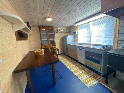 BolidenにあるLoft in the forestのテーブルと冷蔵庫のある小さなキッチン