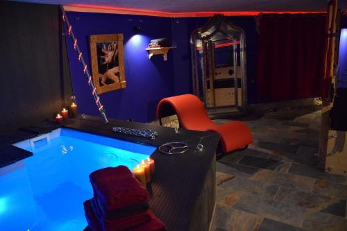 Cette chambre dispose d'une piscine avec une chaise et une table. dans l'établissement loveroom Bdsm - LSK, à Ucel
