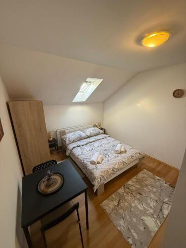 ein Schlafzimmer im Dachgeschoss mit zwei Betten und einem Tisch in der Unterkunft Sobe Ježdovec in Ježdovec