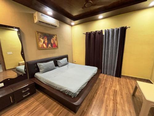 a bedroom with a bed and a large mirror at GoBravo 37 - 2Bhk Farm with Pool & Garden Sec150 Noida in Greater Noida