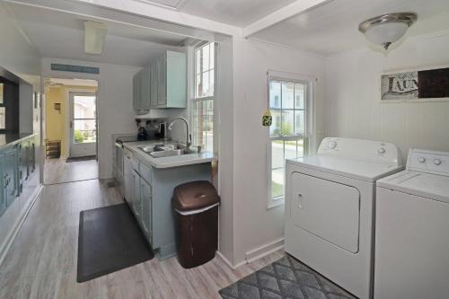 a kitchen with a sink and a washer and dryer at Hill House - Pet friendly, In town with water views! in Chincoteague
