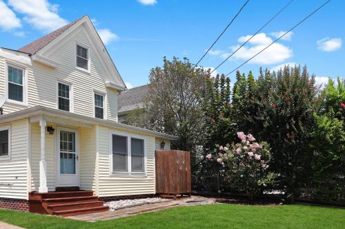 a white house with a fence in the yard at Hill House - Pet friendly, In town with water views! in Chincoteague