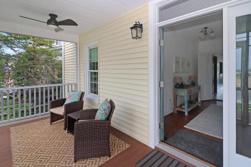 a screened in porch with chairs and a table at Hill House - Pet friendly, In town with water views! in Chincoteague