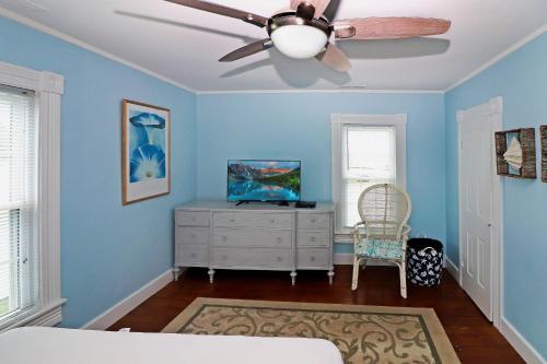 a bedroom with blue walls and a ceiling fan at Hill House - Pet friendly, In town with water views! in Chincoteague