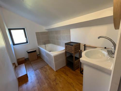 une salle de bain avec une baignoire et un lavabo dans l'établissement Les Ecuries du Château, à Gravigny