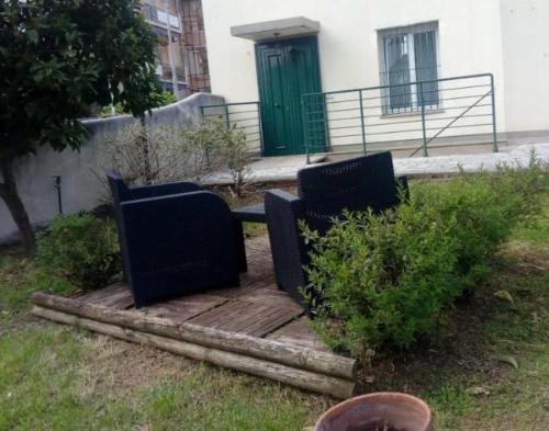 two benches sitting on a wooden path in front of a building at Al villino Duse in Genova