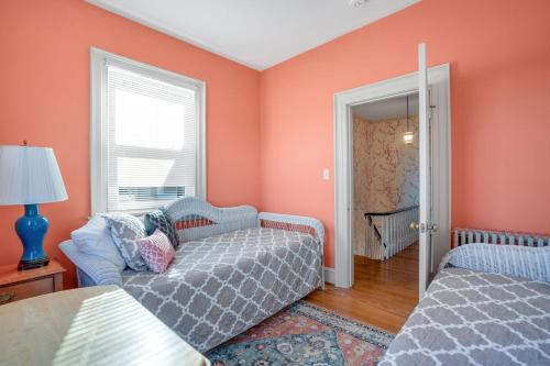 a living room with orange walls and a couch at Huntington Farm - Pristine Historical Home Overlooking Cherrystone Creek! in Cape Charles