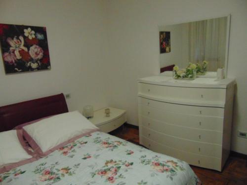 a bedroom with a bed and a dresser and a mirror at Podere Luma Camera Gelsomino - Lavanda in Gambassi Terme
