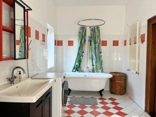 a bathroom with a tub and a sink at Großzügige Gutshaus-Wohnung nahe Saale und Elbe in Schwarz