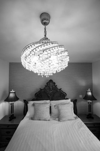 a bedroom with a large chandelier and a bed at Harvest House with Games Room in Stirling