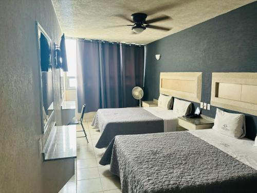 a hotel room with two beds and a ceiling fan at Hotel Union Guadalajara in Guadalajara