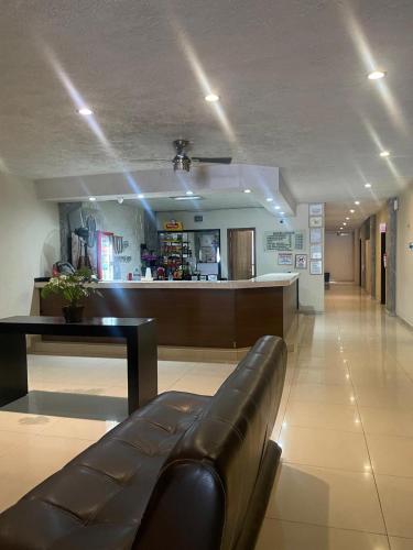 a lobby with a leather couch in the middle of a room at Hotel Union Guadalajara in Guadalajara