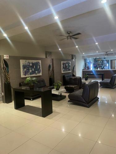 a living room with couches and a ceiling fan at Hotel Union Guadalajara in Guadalajara