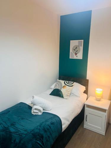 a small bedroom with a bed and a side table at Waterside Stay- 3 Bed House- Sleeps 5- Parking- Fast Wifi in Burton upon Trent