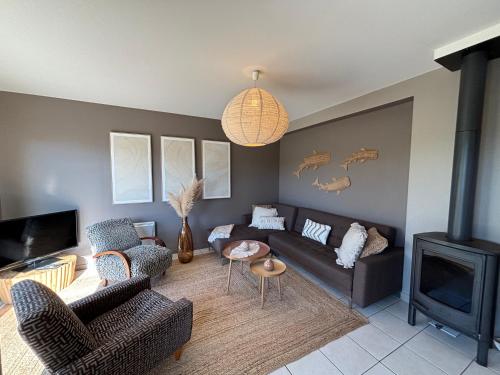 a living room with a couch and a fireplace at Le Cocon Iodé - 100m des plages-GR34-skatepark-kite-surf-voile-terrasse-jardin in Clohars-Carnoët