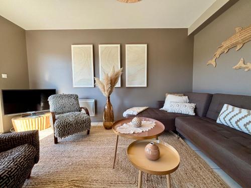 a living room with a couch and a table at Le Cocon Iodé - 100m des plages-GR34-skatepark-kite-surf-voile-terrasse-jardin in Clohars-Carnoët