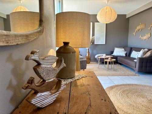a living room with a table with a bird vase on it at Le Cocon Iodé - 100m des plages-GR34-skatepark-kite-surf-voile-terrasse-jardin in Clohars-Carnoët