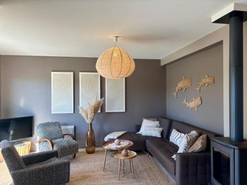 a living room with a brown couch and chairs at Le Cocon Iodé - 100m des plages-GR34-skatepark-kite-surf-voile-terrasse-jardin in Clohars-Carnoët