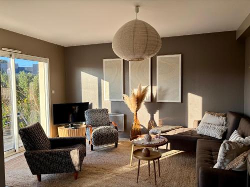 a living room with a couch and chairs at Le Cocon Iodé - 100m des plages-GR34-skatepark-kite-surf-voile-terrasse-jardin in Clohars-Carnoët