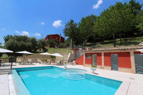 una piscina frente a un edificio rojo en Ferienhaus Casa Sacciofa In Monte Rinaldo, en Monte Rinaldo