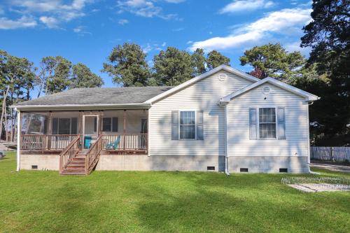 a white house with a deck on a yard at Horseshoe Hideaway - Cozy home with screened porches! in Birch Town