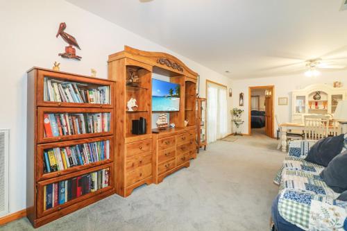 a living room with a large wooden book shelf at Horseshoe Hideaway - Cozy home with screened porches! in Birch Town