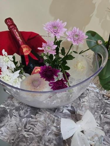 eine Glasschüssel mit Blumen auf dem Tisch in der Unterkunft Cozy Cabin in Midrand