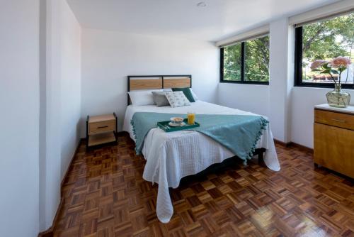 a bedroom with a bed with a tray on it at Departamento en Coyoacán 7 in Mexico City