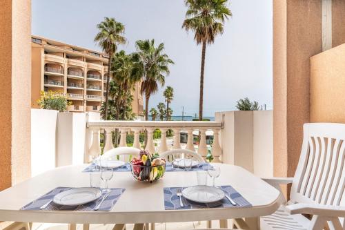 - une table blanche avec un bol de fruits sur le balcon dans l'établissement Family Sea view with pools near shops and beaches, à Cannes