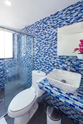 a blue tiled bathroom with a toilet and a sink at Departamento en Coyoacán 7 in Mexico City